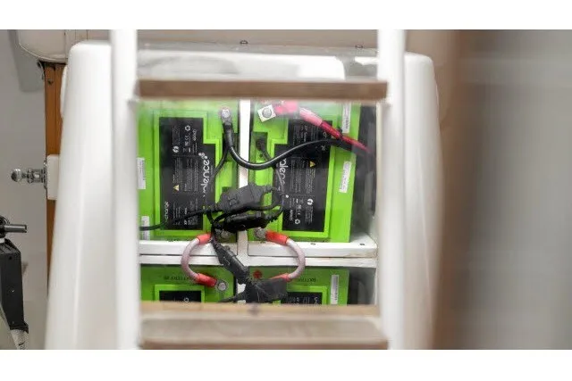 Slide: The Image of Battery compartment of a 2005 J Boats J/100 sailboat, featuring green batteries and wiring. - 25
