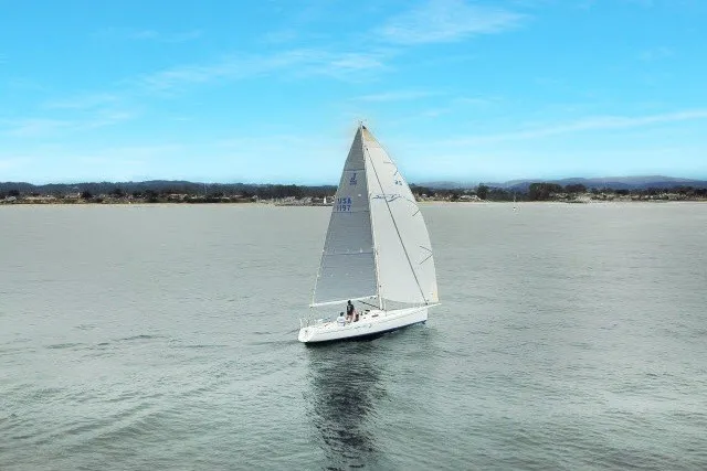 Slide: The Image of 2005 J Boats J/100 sailing on calm waters under a clear blue sky. - 39