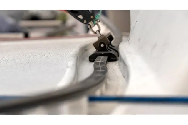 Slide: The Image of Close-up of a 2005 J Boats J/100 sailboat deck detail, featuring a track and fitting. - 28