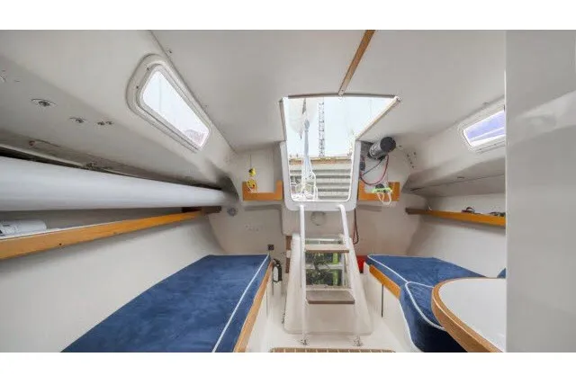 Slide: The Image of Interior of 2005 J Boats J/100 sailboat with blue seating and wooden accents. - 7