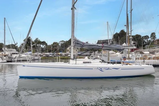 The Image of 2005 J Boats J/100 sailboat docked in a marina, calm water, clear sky. - 1