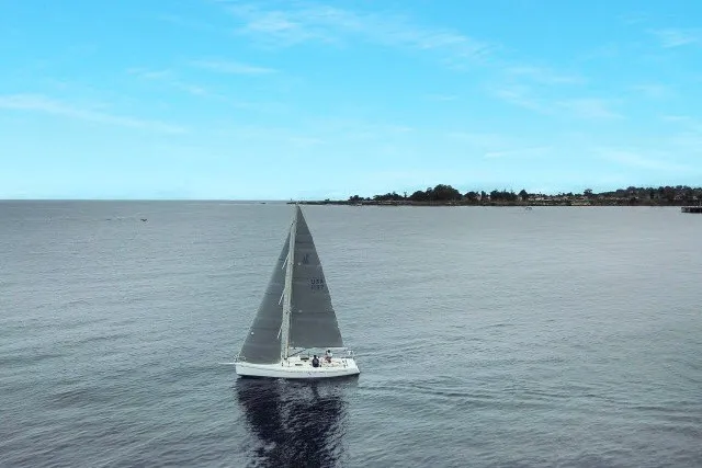 Slide: The Image of Sailboat J/100 by J Boats (2005) cruising on calm ocean under clear blue sky. - 34