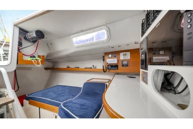 Slide: The Image of Interior of 2005 J Boats J/100 sailboat with blue seating and navigation equipment. - 23