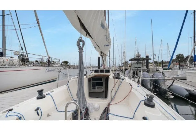 Slide: The Image of 2005 J Boats J/100 sailboat docked in a marina, surrounded by other vessels. - 16