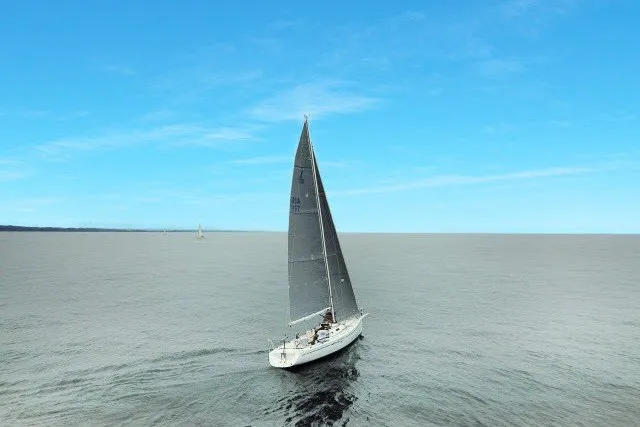 Slide: The Image of Sailboat J/100 from 2005 cruising on calm waters under a clear blue sky. - 36