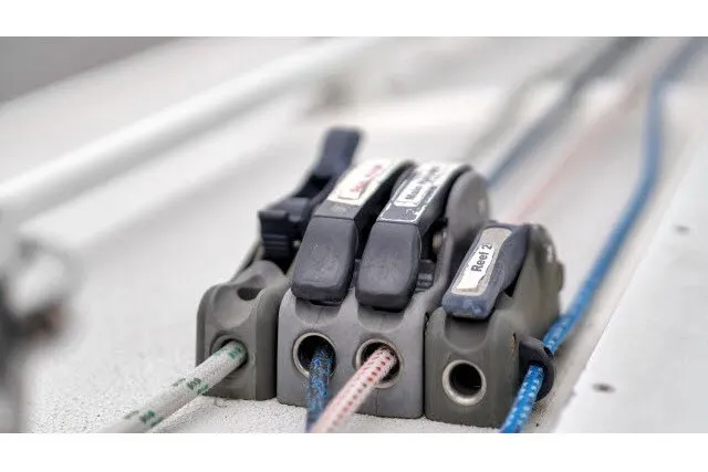 Slide: The Image of Close-up of J/100 sailboat rope clutches, 2005 model, featuring colorful ropes and labeled levers. - 5