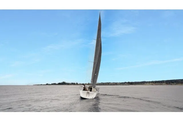 Slide: The Image of 2005 J Boats J/100 sailing on open water under a clear blue sky. - 42