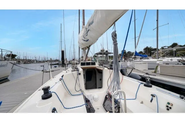 Slide: The Image of 2005 J Boats J/100 sailboat docked at marina, showcasing cockpit and rigging. - 15