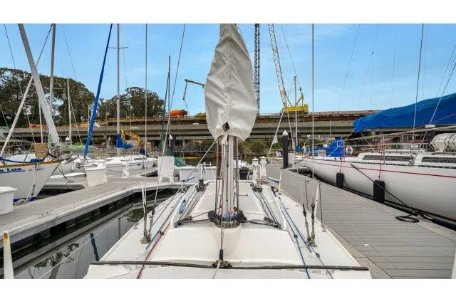Slide: The Image of 2005 J Boats J/100 sailboat docked at marina, surrounded by other vessels. - 32