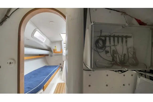 Slide: The Image of 2005 J Boats J/100 interior cabin with blue cushioned berth and electrical panel. - 21