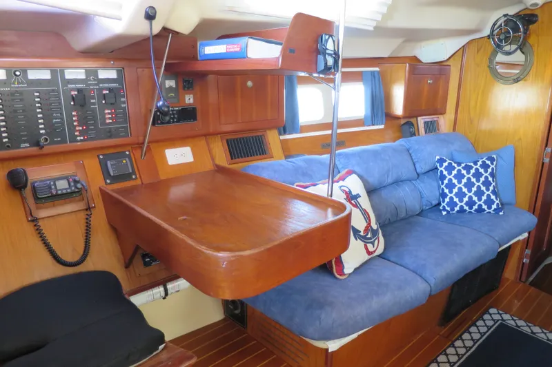 Slide: The Image of Interior of 2000 Hunter Legend 410 yacht with blue sofa and wooden table. - 14