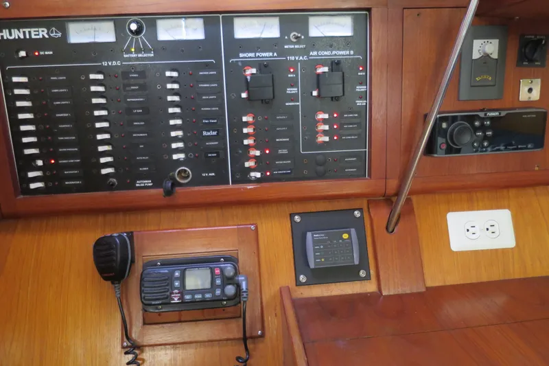Slide: The Image of Control panel of a 2000 Hunter Legend 410 sailboat with various switches and gauges. - 15