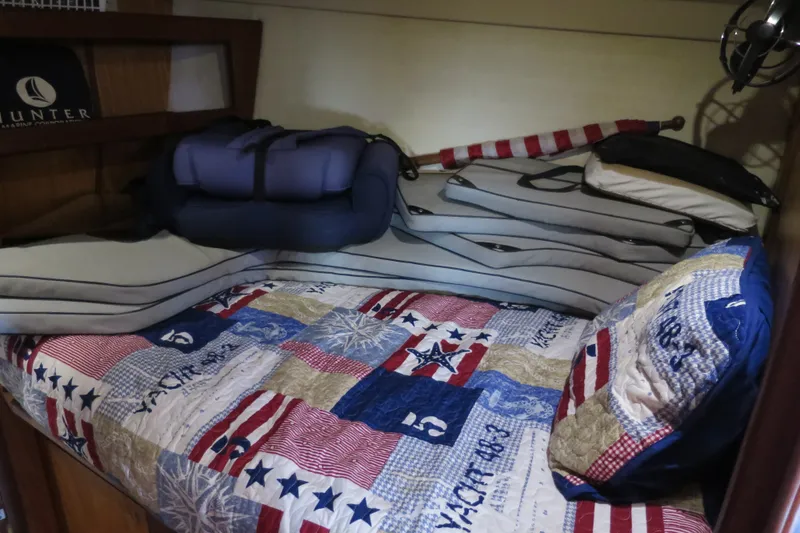 Slide: The Image of Cozy cabin bed in 2000 Hunter Legend 410 yacht with nautical-themed quilt and cushions. - 18