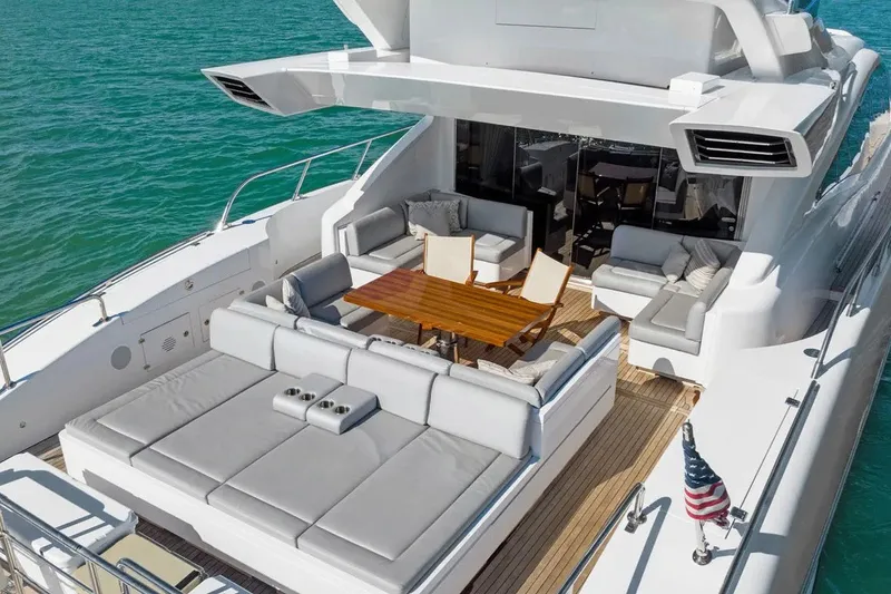 Slide: The Image of Luxurious 2016 Mangusta 94 yacht deck with elegant seating and wooden table on turquoise water. - 15