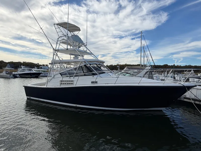 The Image of A 1993 Rampage Express Sportfish is docked in the water, surrounded by other boats. - 1