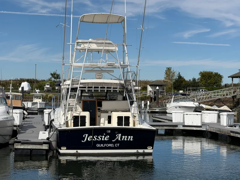 Slide: The Image of A 1993 Rampage Express Sportfish docked in the marina. The name "Jessie Ann" is visible on the stern. - 9