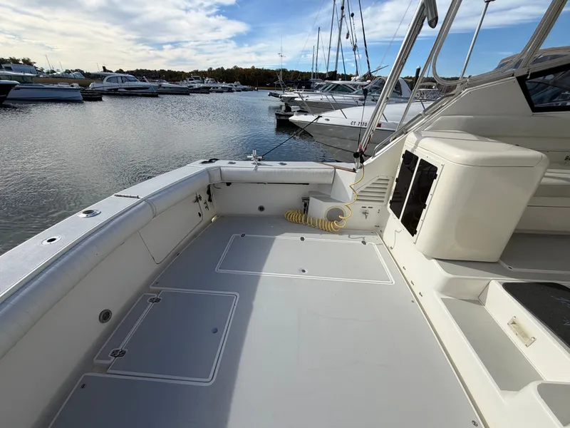 Slide: The Image of The image shows the spacious aft deck of a 1993 Rampage Express Sportfish in a marina. - 32