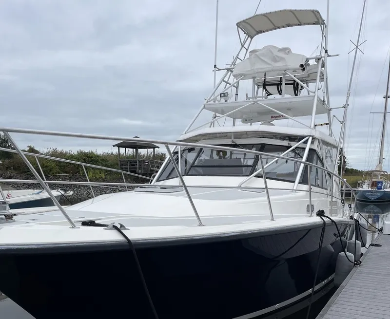 Slide: The Image of A 1993 Rampage Express Sportfish docked. It features a sturdy design and a tall tower. - 4