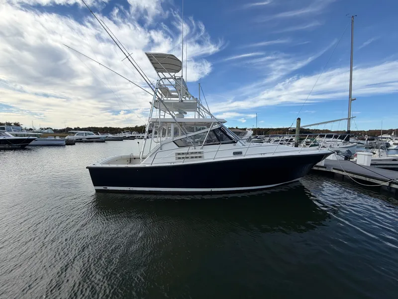 Slide: The Image of A 1993 Rampage Express Sportfish is docked in the water, surrounded by other boats in the harbor. - 6