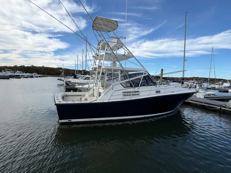 Slide: The Image of A 1993 Rampage Express Sportfish is docked in the water, surrounded by other boats in the marina. - 7