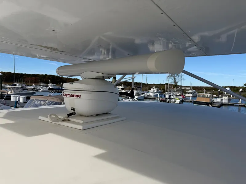 Slide: The Image of A radar on a boat's roof overlooking a marina filled with boats. - 27