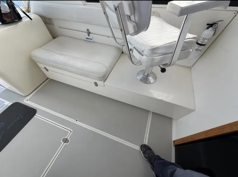 Slide: The Image of Interior of a 1993 Rampage Express Sportfish with white seating and a fire extinguisher. - 17
