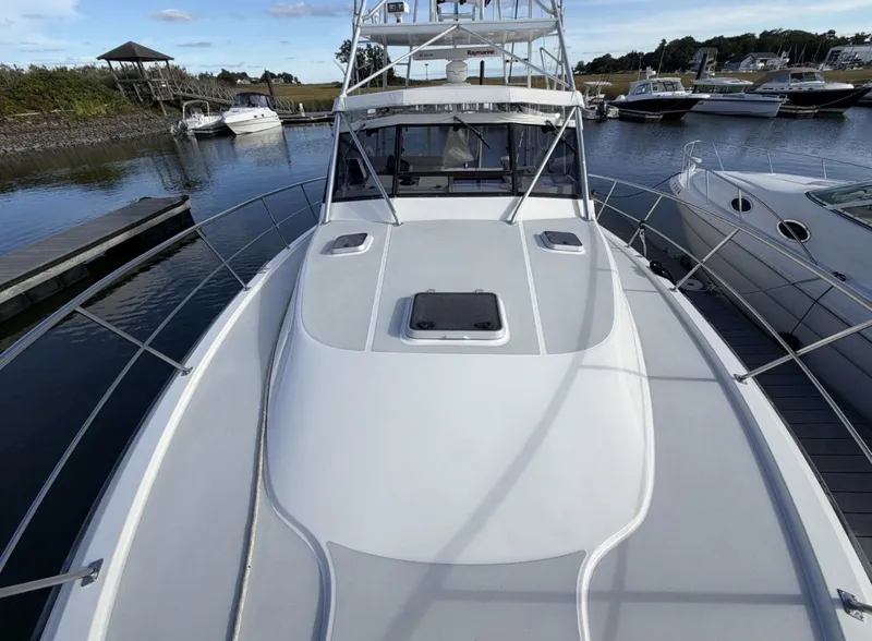 Slide: The Image of A 1993 Rampage Express Sportfish docked in a calm marina with other boats. - 13