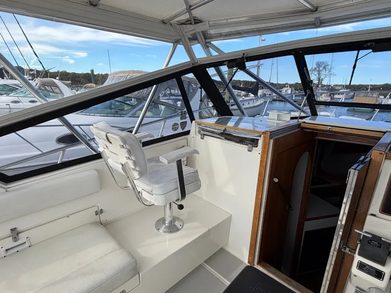 Slide: The Image of The cockpit of a 1993 Rampage Express Sportfish with a white captain's chair and wooden doors. - 49