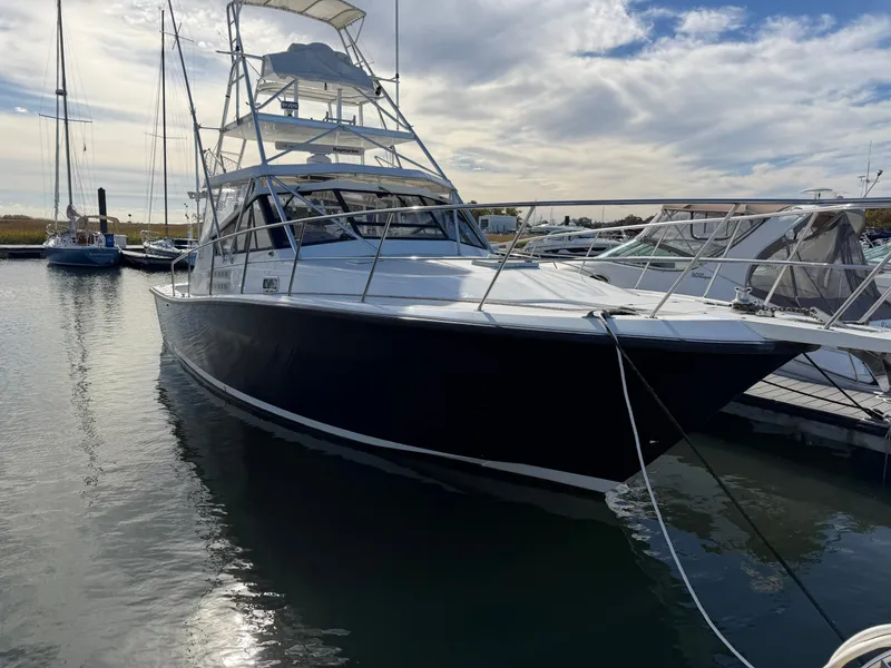 Slide: The Image of 1993 Rampage Express Sportfish docked, featuring a distinctive tower and sleek black hull. - 3