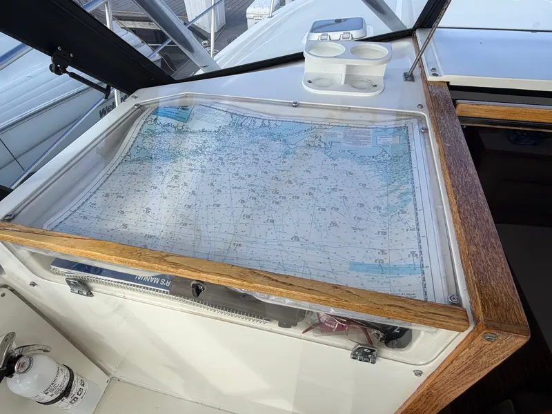 Slide: The Image of A navigation area with a nautical chart under plexiglass on a 1993 Rampage Express Sportfish. - 50
