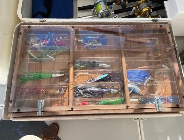 Slide: The Image of Fishing lures and gear in a transparent container on a boat. - 18