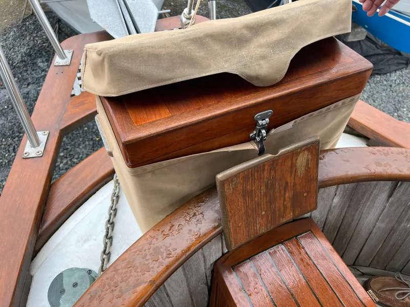 Slide: The Image of Wood-paneled area of a sailboat with seating and a covered compartment. - 7