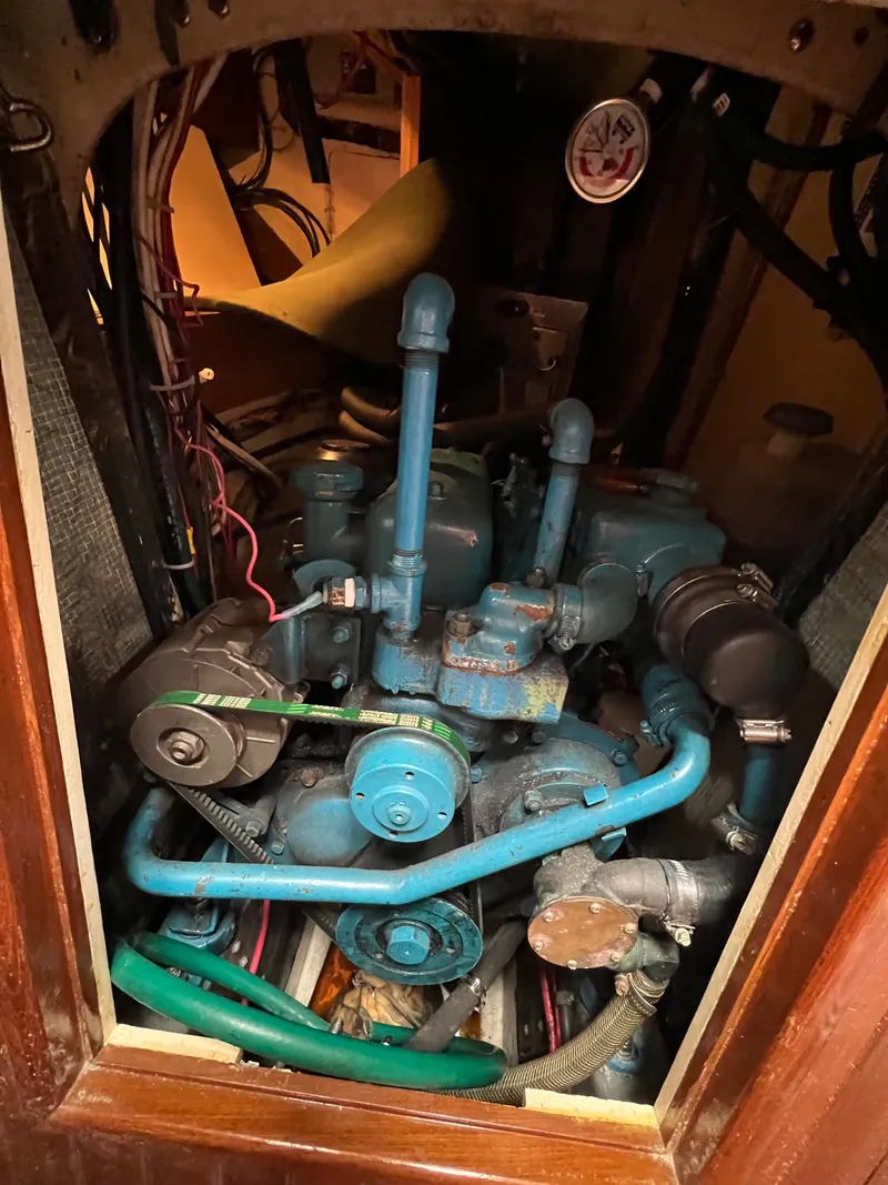 Slide: The Image of The engine room of a 1983 Union Cutter shows a blue engine with hoses and wires. - 21