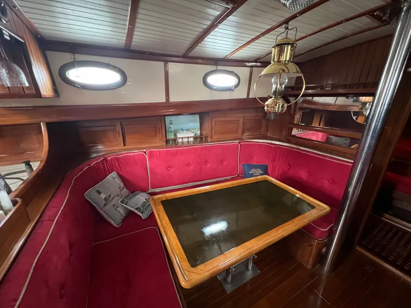Slide: The Image of Cozy saloon with red upholstery and wooden table on a 1983 Union Cutter. - 16