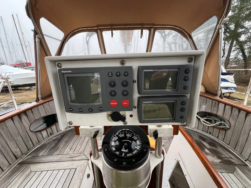 Slide: The Image of The cockpit of a 1983 Union Cutter with navigation instruments and a compass. - 10
