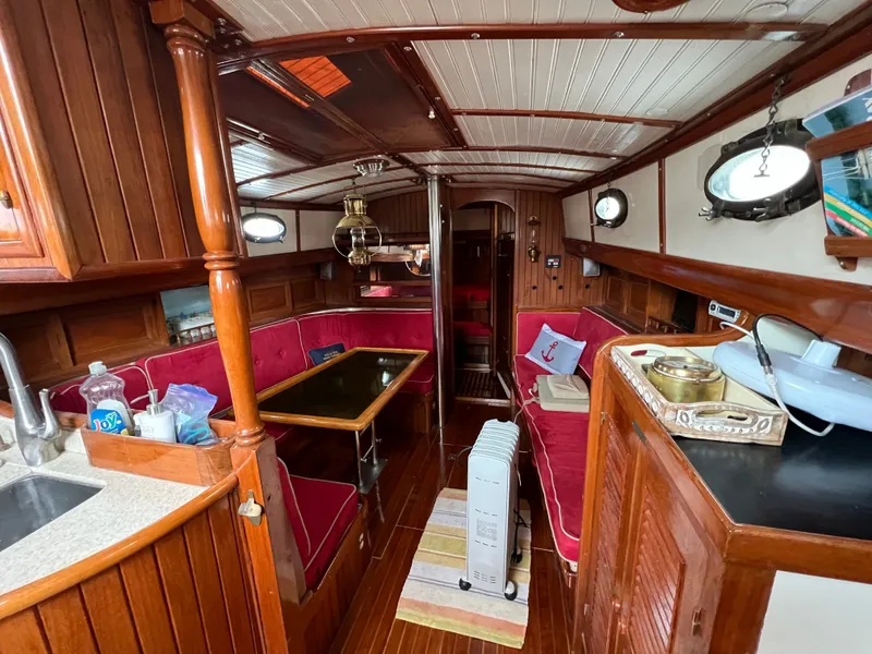 Slide: The Image of Interior of a 1983 Union Cutter with wood paneling and red upholstery. - 11