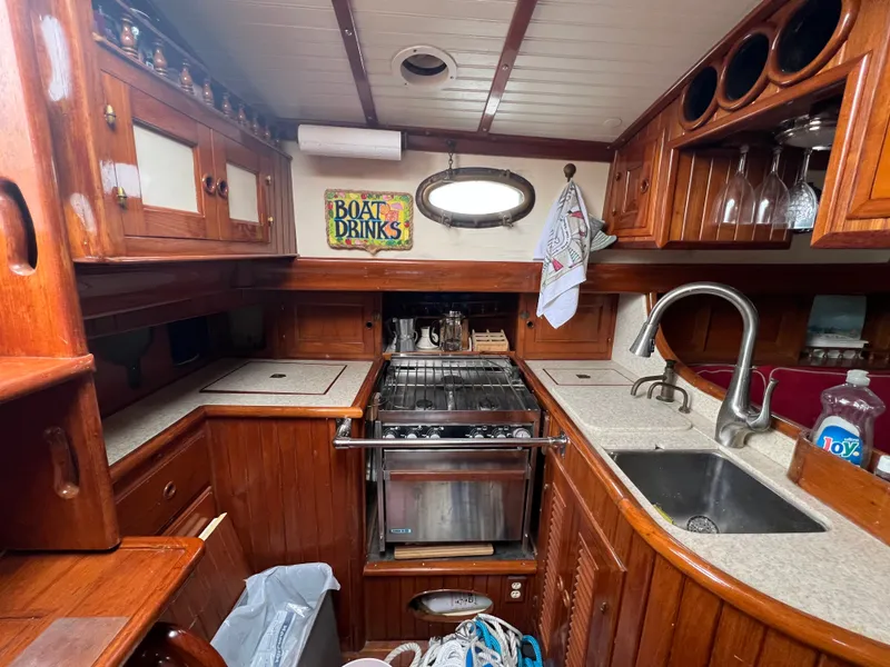Slide: The Image of Classic wooden galley in a sailboat with stove, sink, and cabinets. - 12