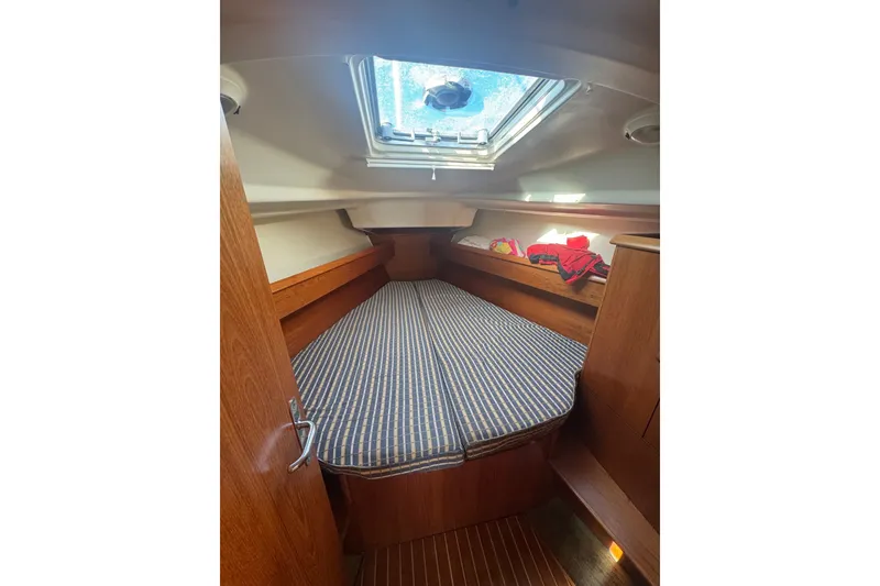Slide: The Image of Cozy cabin interior of 2004 Jeanneau Sun Odyssey 37 sailboat with striped bedding. - 8