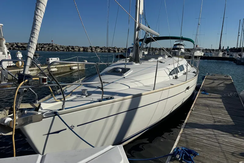 The Image of 2004 Jeanneau Sun Odyssey 37 sailboat docked at a marina under clear blue skies. - 0