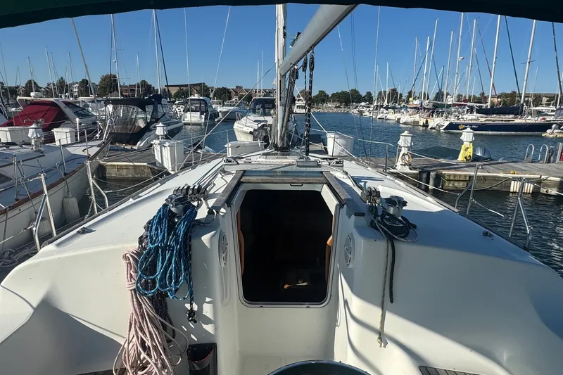 Slide: The Image of Jeanneau Sun Odyssey 37 sailboat docked at marina, view of deck and open cabin. - 2