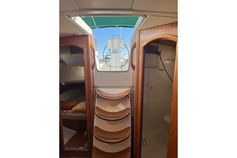 Slide: The Image of Interior view of 2004 Jeanneau Sun Odyssey 37 sailboat, featuring wooden cabinetry and compact design. - 4