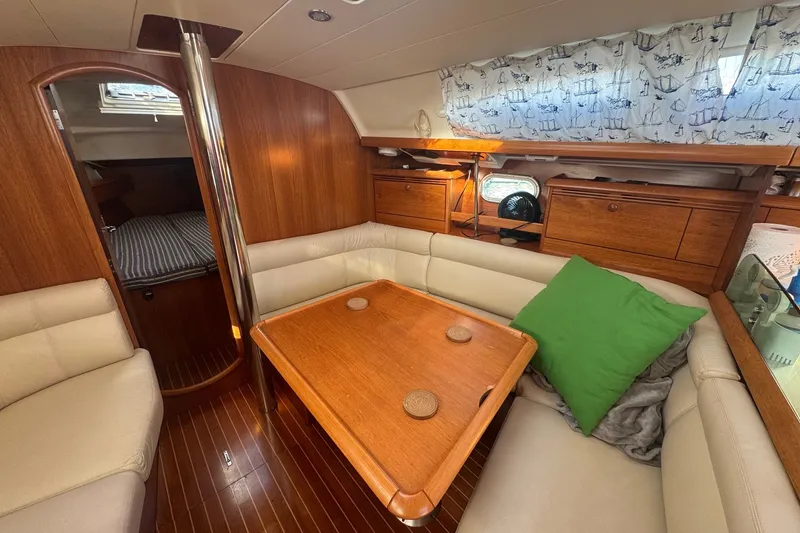 Slide: The Image of Interior of 2004 Jeanneau Sun Odyssey 37 sailboat with cozy seating and wooden finishes. - 7