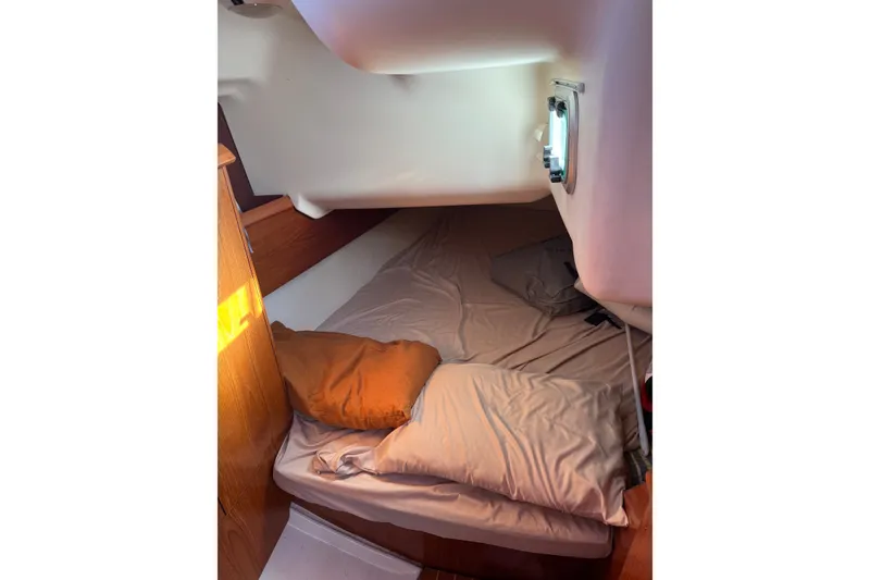Slide: The Image of Cozy cabin interior of 2004 Jeanneau Sun Odyssey 37 sailboat with bedding and porthole. - 6