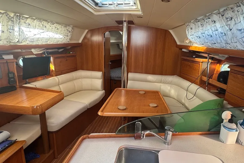 Slide: The Image of Interior of 2004 Jeanneau Sun Odyssey 37 sailboat with cozy seating and wooden finishes. - 9