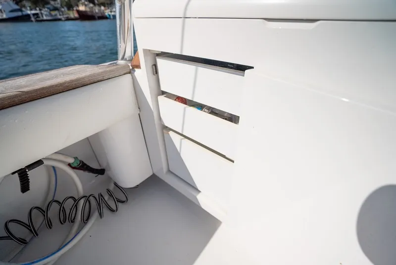 Slide: The Image of Close-up of a white storage area on a boat, featuring drawers and cables nearby. - 23