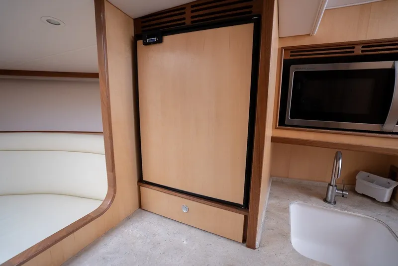 Slide: The Image of Yacht interior with a fridge, microwave, and sink in a sleek kitchen area. - 48