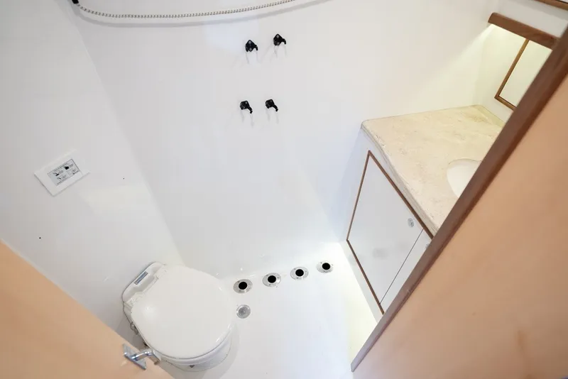 Slide: The Image of The image shows a clean, modern boat bathroom with a toilet and sink. - 49