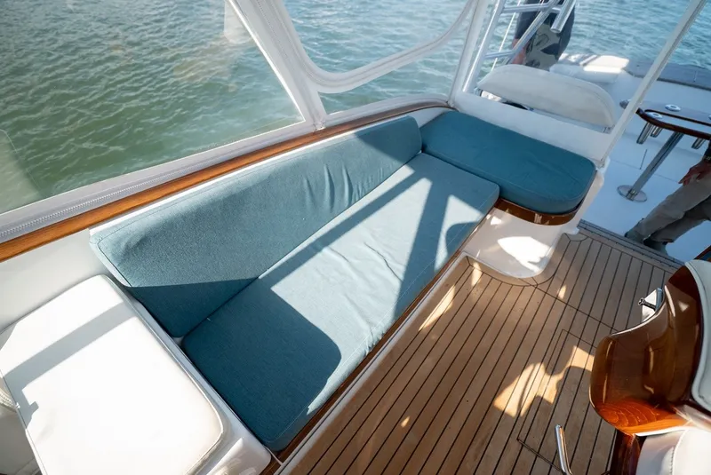 Slide: The Image of Yacht interior with blue cushions and wooden flooring, surrounded by water. - 32