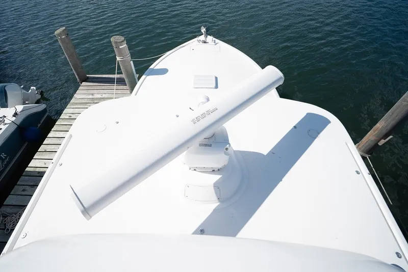 Slide: The Image of The bow of a white sportfish boat at the dock, featuring a large radar on the deck. - 39
