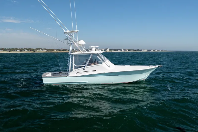 The Image of A 2017 Lightning Custom Yachts 37 Express Sportfish on the sea, featuring a sleek cabin and fishing rods. - 1